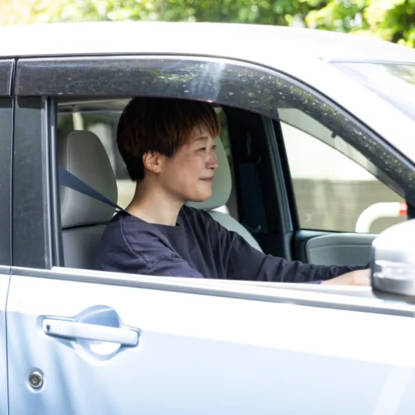 車を運転する女性スタッフ