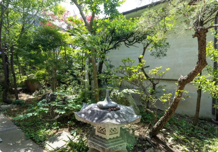 石灯籠と緑豊かな樹木が広がる和風の庭園