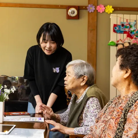 高齢の利用者と笑顔で会話する介護スタッフ